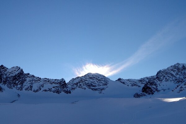 Солнце выходит из-за снежных гор