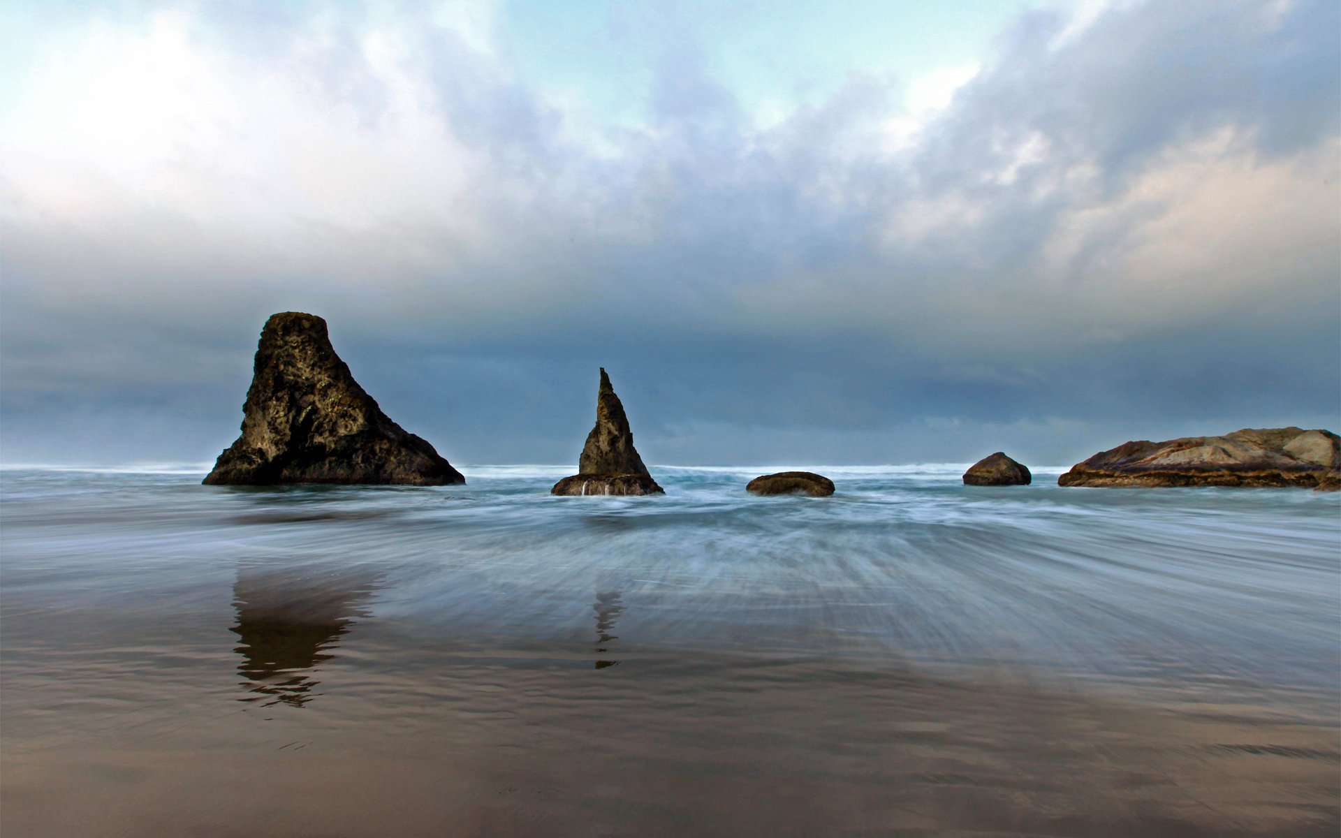 mer roches pierres sable nuages nuageux