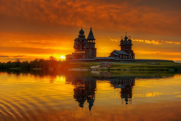 Chiesa di legno di fronte al lago al tramonto