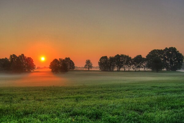 Der Sonnenuntergang erhellt das neblige Tal