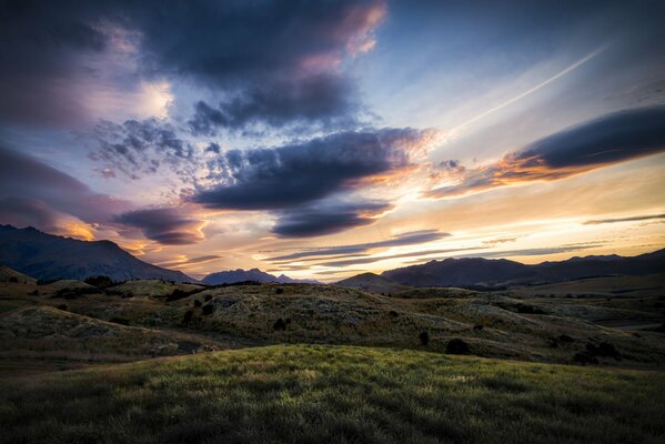 Cielo al amanecer sobre una colina verde