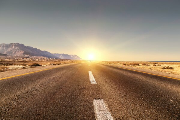 Strada infinita. Il sole tramonta oltre le colline