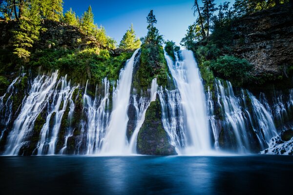 Enorme cascada que fluye desde el acantilado hacia el lago