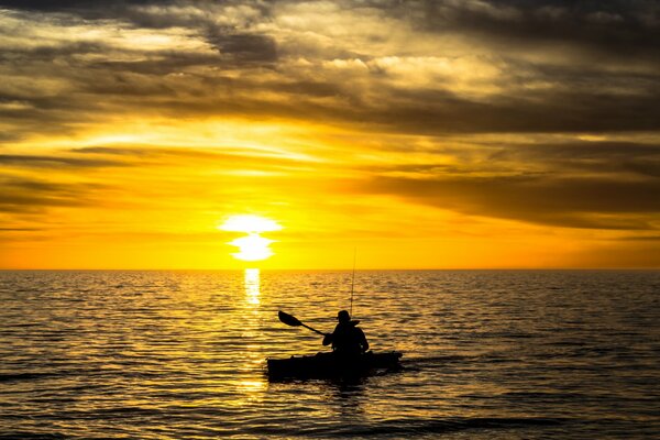 Bateau de pêche sur fond de coucher de soleil de la rivière