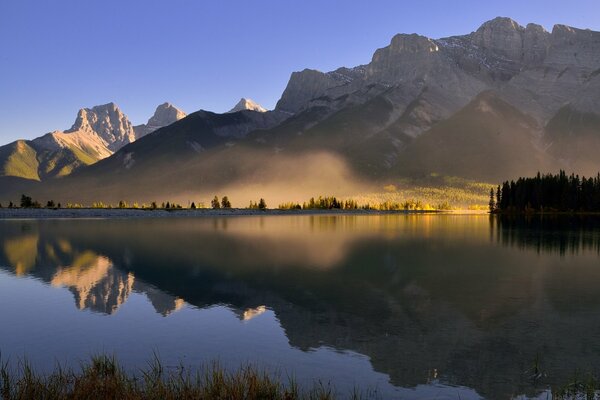 Morning fog on the lake near the mountains