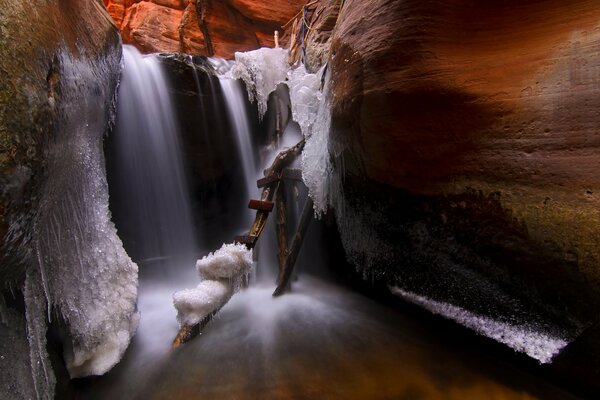 Escalera de madera rodeada de una cueva de hielo