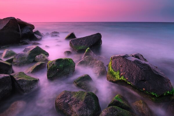 Morze z kamieniami na tle różowego zachodu Słońca