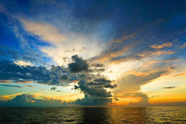 Ruhiges Meer und Sonnenuntergang bewölkter Himmel