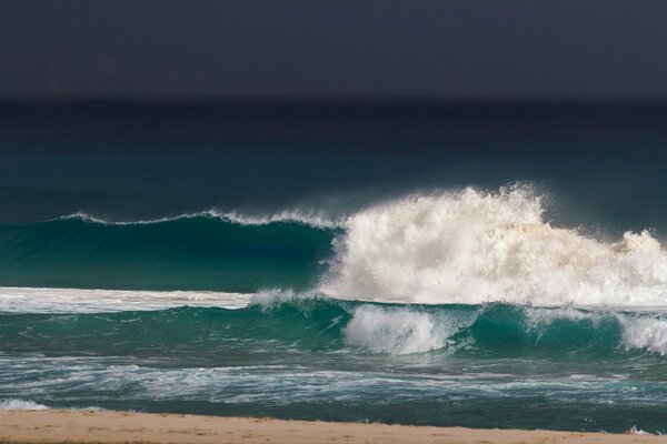 La espuma del mar de las olas en el fondo de las nubes oscuras