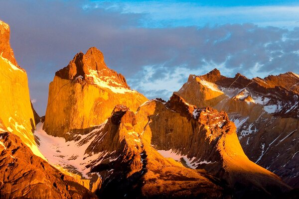 Панорама острых гор, посвеченных заходящим солнцем