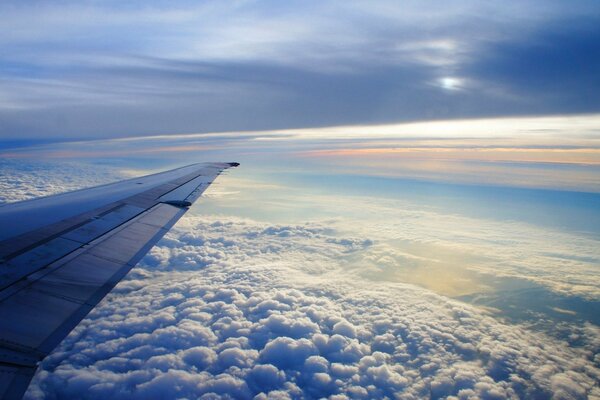 Unter dem Flügel des Flugzeugs sind Wolken