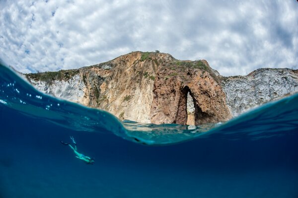 Foto de rocas del océano con un buzo