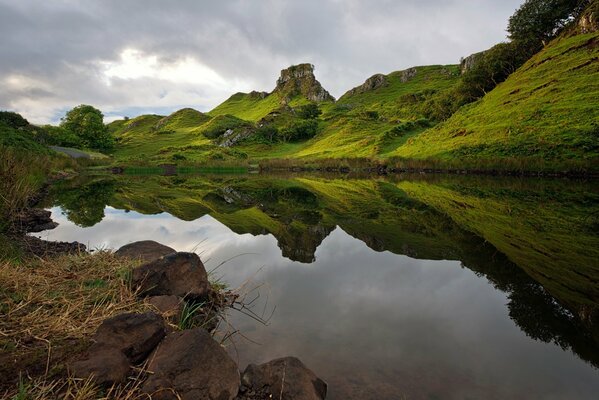 Lac calme au milieu des collines verdoyantes