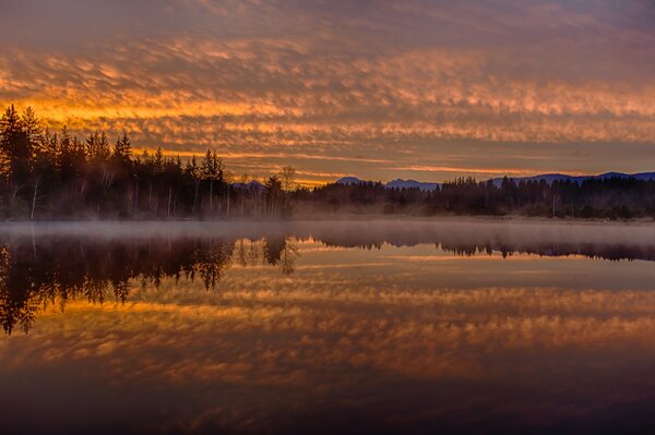 Orange sunset over a misty river