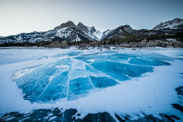 Frozen lake in winter on the background of snow-capped mountains