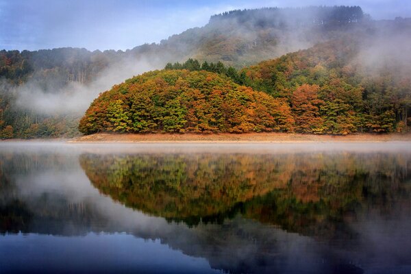 Autumn lake reflects trees