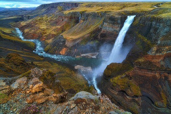 Islandzki wodospad do rzeki kanionu