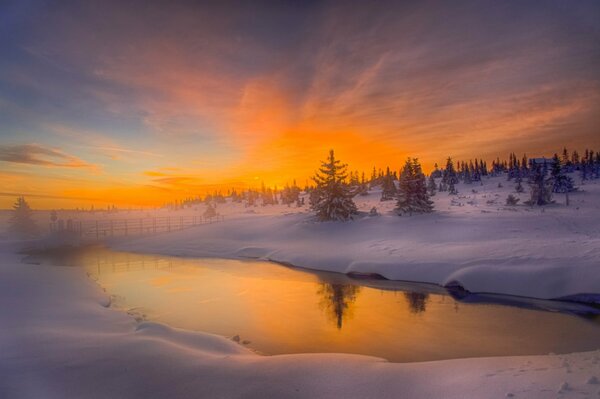 Orange Morgendämmerung am Winterfluss