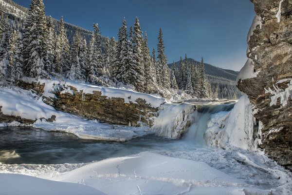 Una cascata nella foresta invernale è una favola