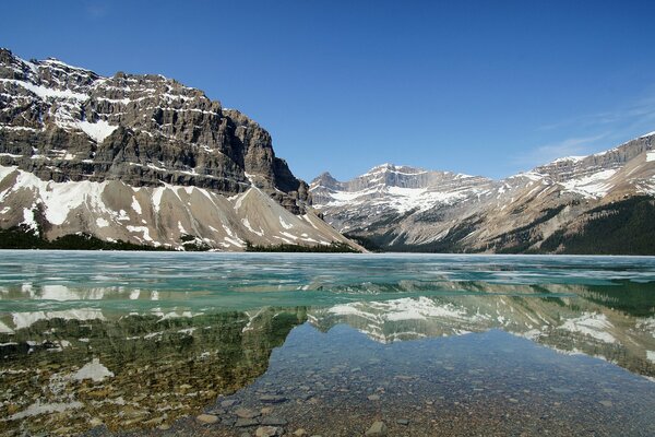 A pond on the background of mountains above a blue sky