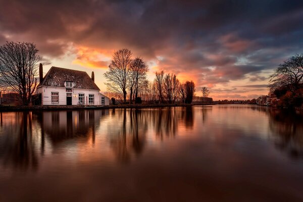 Casa en la orilla del río se refleja en el agua