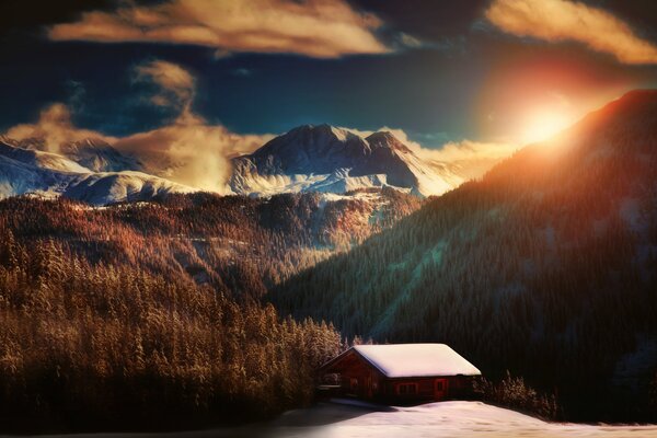 Les rayons du soleil illuminent une maison enneigée dans les montagnes