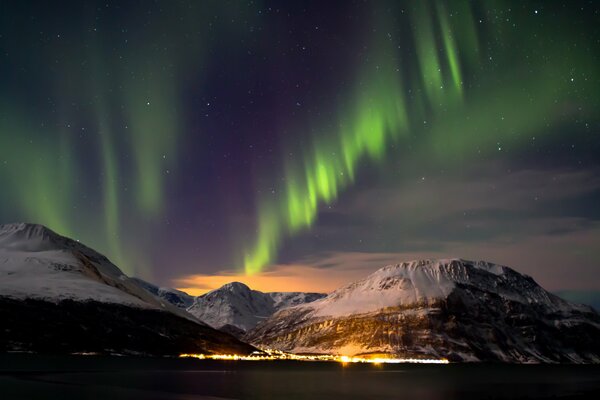 La Aurora boreal en el cielo. Montañas nevadas