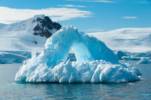 Słoneczna góra lodowa pośrodku zimowego morza