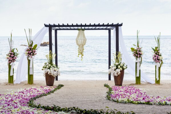 Gazebo on the shore of the sea, there are only flowers around