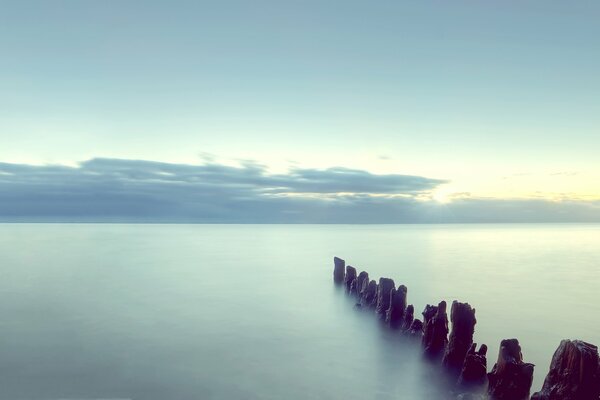 Sunset by the sea and columns in the water