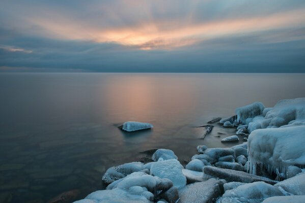 Étang d hiver. Coucher du soleil. Côte de glace