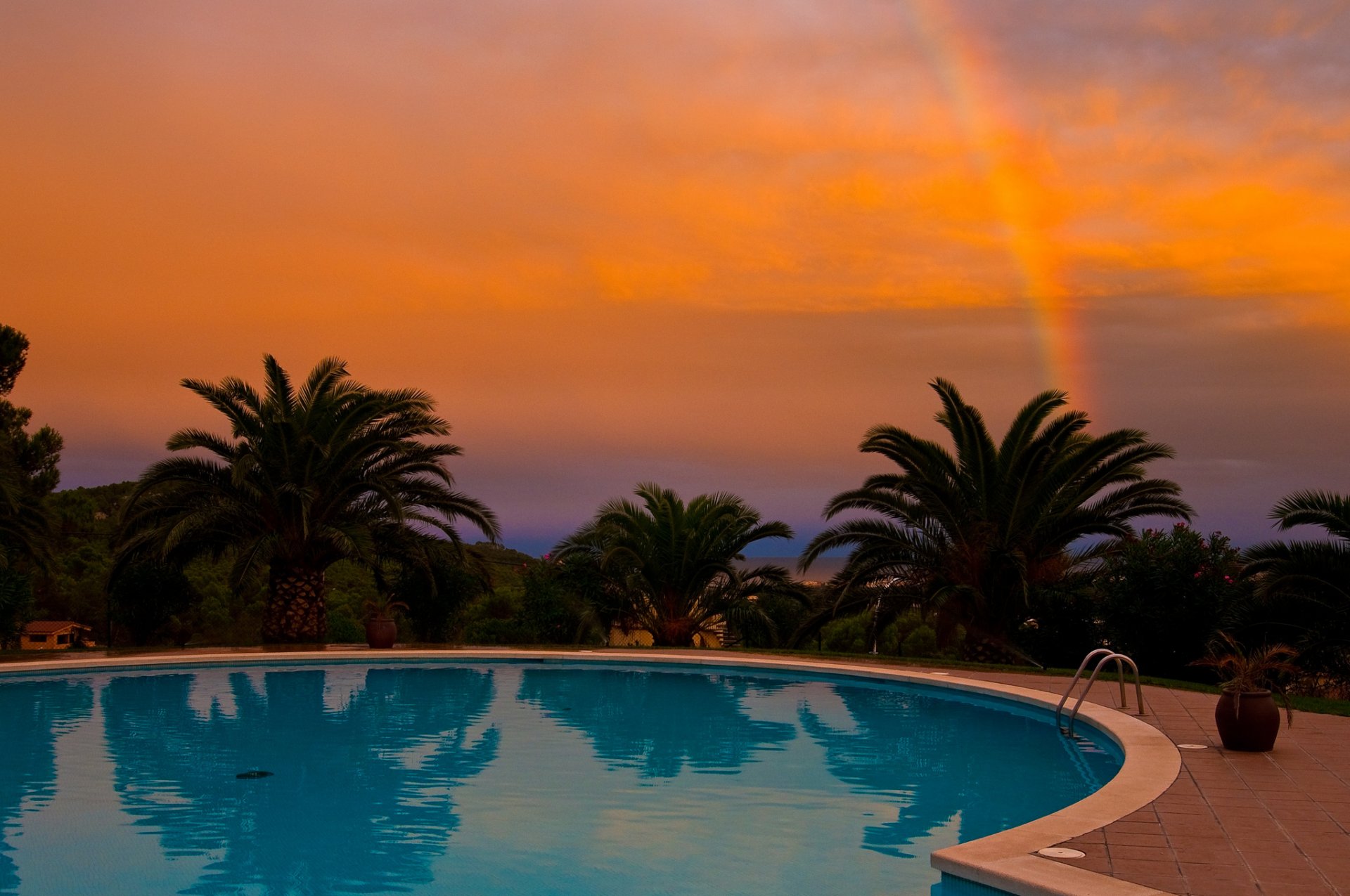 palme tramonto arcobaleno piscina