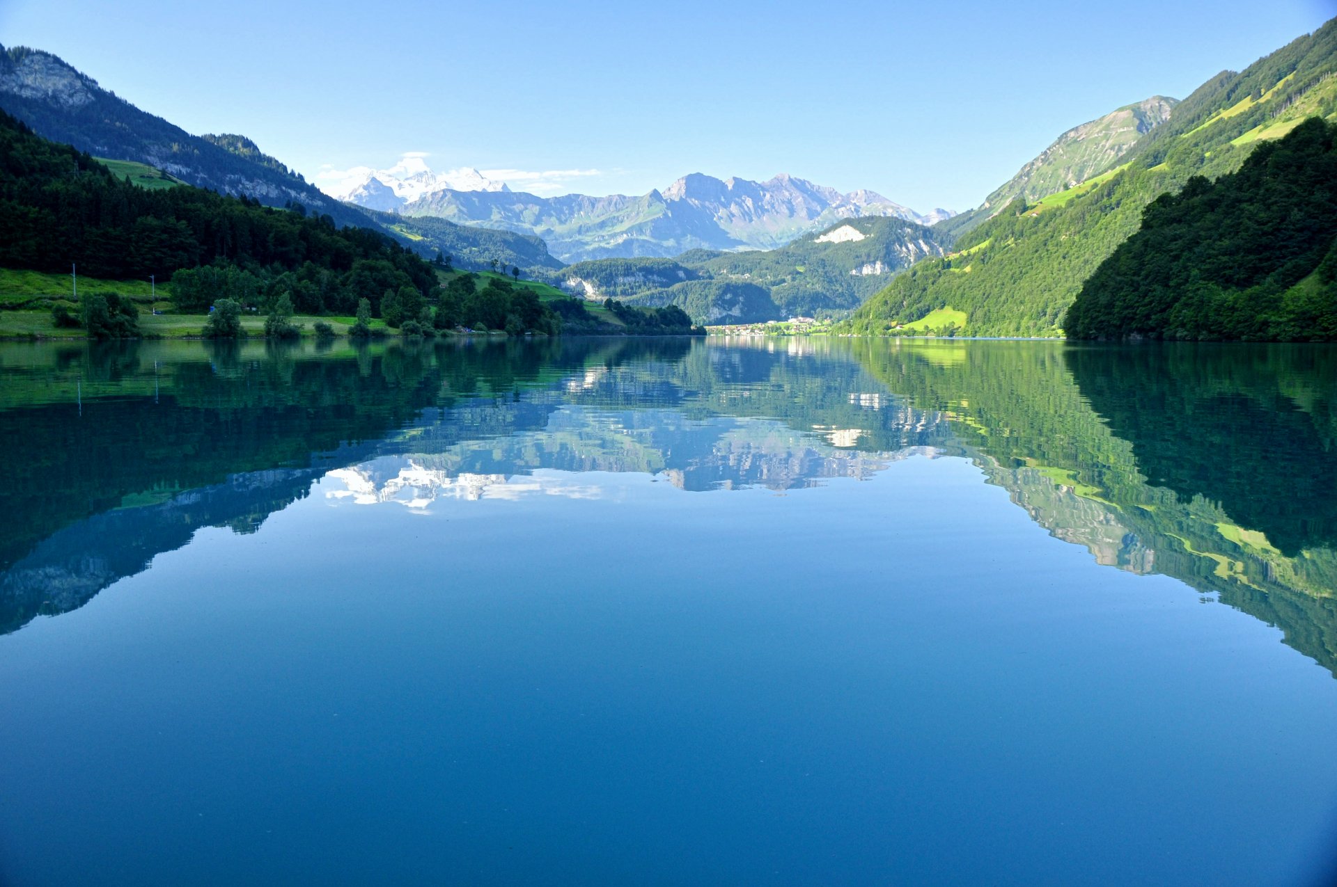 witzerland lake lungern shore forest tree mountain alps tops sky reflection