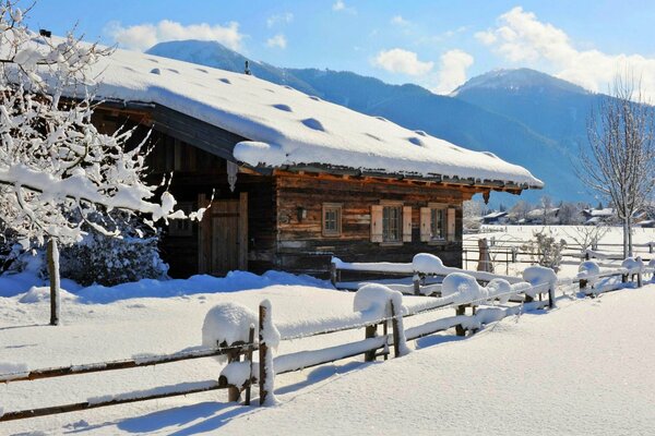 Giornata invernale soleggiata e casa in montagna