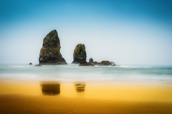 Piękna przyroda skały pośrodku morza i złoty piasek