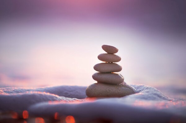 Several stones are stacked in a pyramid on a purple background