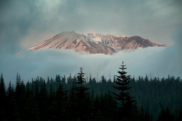 Pico nevado en nubes densas