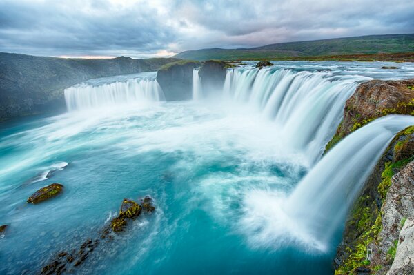 Nubes sobre una cascada con piedras