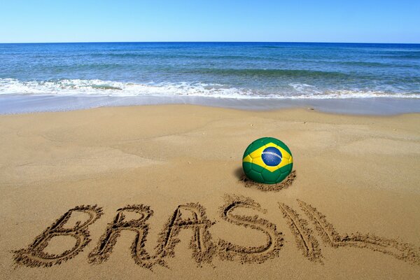 A ball with the image of the flag of Brazil on the seashore