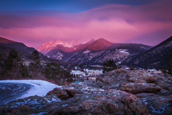 Puesta de sol rosa en cimas de montañas cubiertas de nieve