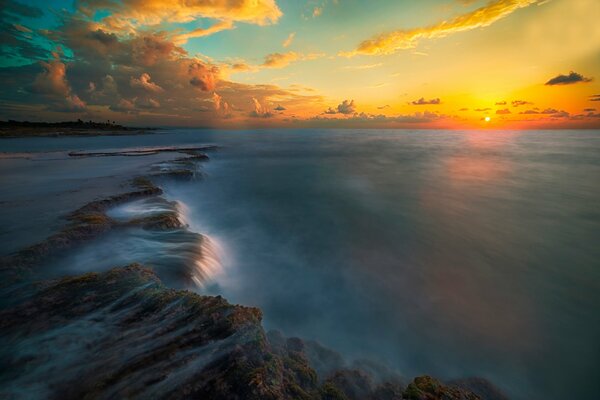 Puesta de sol en la costa con hermosas nubes