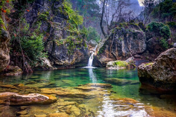 Landschaft See zwischen Felsen mit Wasserfall