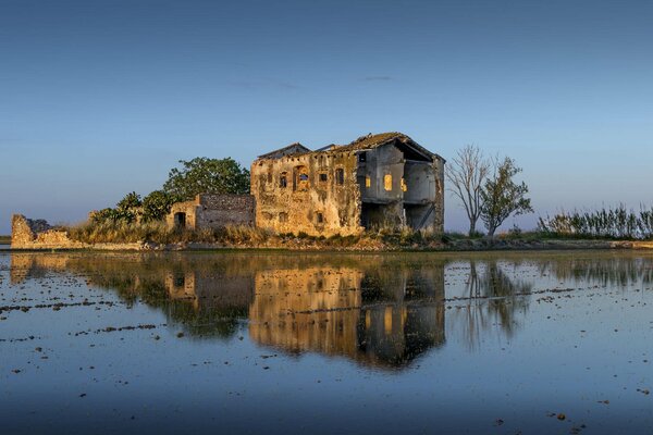 Las ruinas de una finca en ruinas se reflejan en el lago