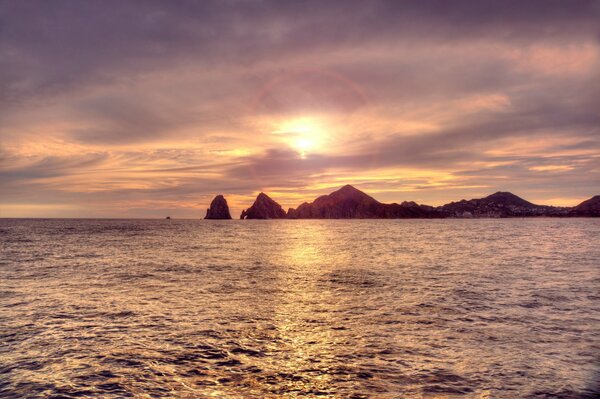 Tramonto sul mare. Rocce in lontananza