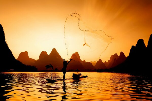 A fisherman casting a net, at sunset