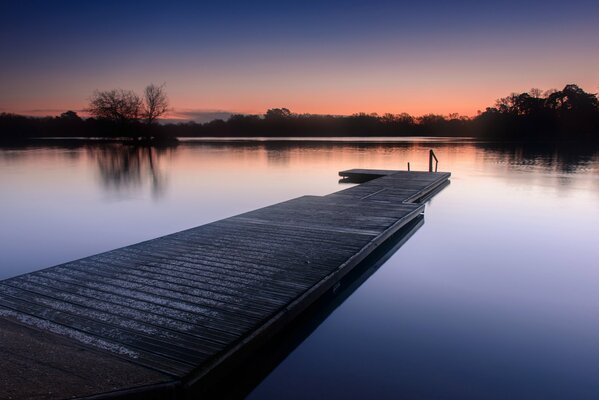 Sonnenuntergang in England, Holzbrücke über der Spiegelfläche des Sees