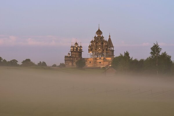 Iglesia en una colina en la niebla en verano