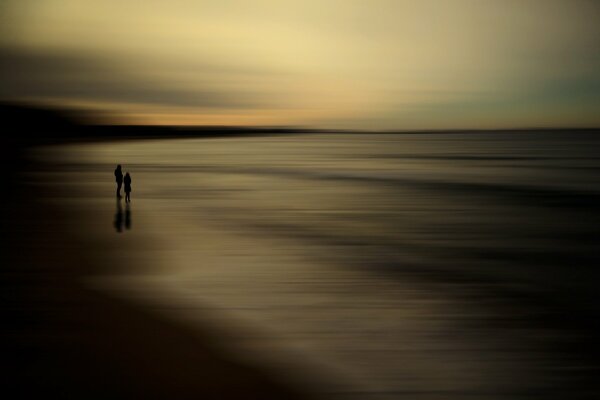 Two silhouettes on the seashore