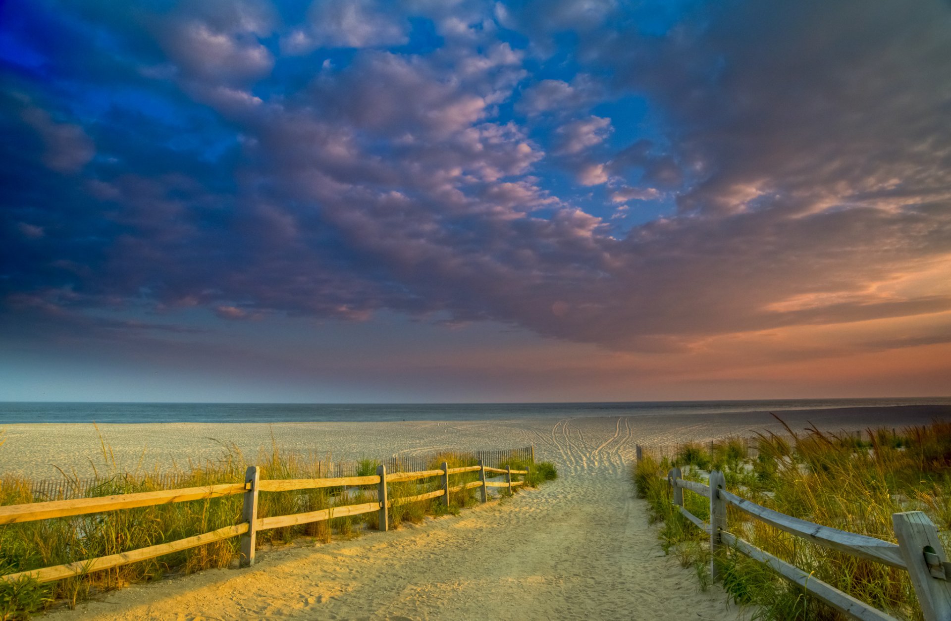 meer strand sand zaun gras himmel