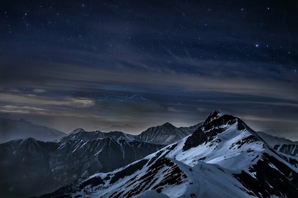 Picos nevados de las montañas por la noche